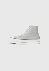High-top sneakers in light gray canvas, featuring white laces, a white rubber sole, and a black stripe along the base.