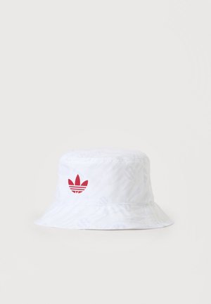 Chapeau bob blanc avec un motif subtil et le logo rouge Adidas trefoil sur le devant centré sur un fond uni.