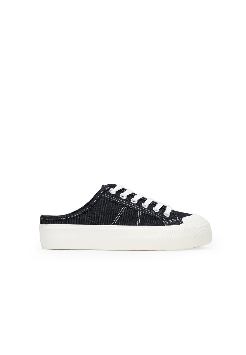 Zapatillas slip-on de denim negro con suela de goma blanca, puntera redondeada y diseño clásico de cordones. Presenta costuras blancas y una parte superior texturizada.