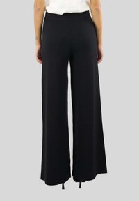 Pantaloni neri a gamba larga con una vita a costine, realizzati in tessuto morbido, caratterizzati da una superficie liscia e un design lungo fino al pavimento.