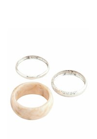 Ensemble de trois bagues : une en résine beige lisse, une en argent brillant avec une surface texturée, et une bande en argent poli.