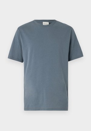 Camiseta de manga corta en suave algodón azul medio. Presenta un cuello redondo clásico, corte recto y detalles de costura mínimos.