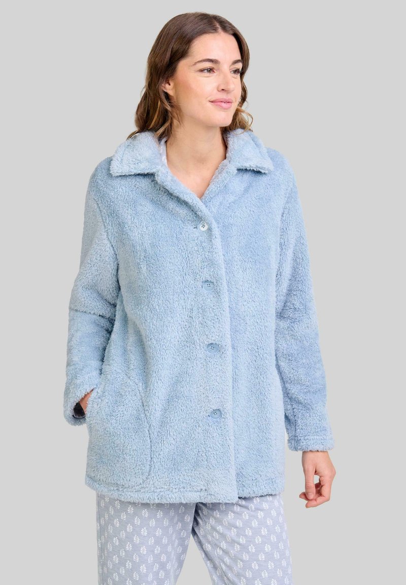 Chaqueta de forro polar de color azul claro y esponjoso, con cuello con muesca, botones frontales y bolsillos laterales. Combinada con pantalones de pijama de estampado.