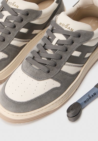 Szare i kremowe sneakersy z zamszu i skóry z perforowaną czubkiem, teksturowanymi akcentami, szarymi sznurówkami i markowym językiem. Zawiera dopasowane sznurówki.