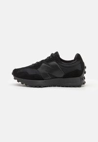 Schwarze Sportschuhe mit einem Obermaterial aus Mesh, Wildlederelementen, einer strukturierten Gummisohle und einem hervorgehobenen Logo an der Seite.
