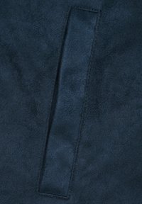 Tessuto scamosciato blu navy con una texture liscia, caratterizzato da una toppa rettangolare cucita per il grip o come accent design.
