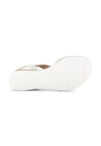 White flat sandal with textured rubber sole, light straps, and a cushioned footbed. Simple design for comfort and ease in wear.