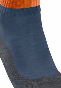 Calzino blu alla caviglia con suola e tallone grigio, bordo arancione e piccolo dettaglio rosso vicino all'area delle dita.