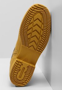 Suela de goma con un patrón de banda de rodadura en zigzag, predominantemente amarilla con acentos negros, diseñada para ofrecer tracción y durabilidad. Talla 37 marcada.