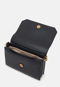 Musta tekstuuripinnaline nahakott, millel on kuldne klapp ja sisemine liblikasalong, beež vooder ja ristkülikukujuline kuju.