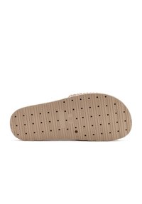 Beige rubberen zool met horizontale groeven en perforaties. Gladde textuur, met een lichte holte. Eenvoudig en strak ontwerp.