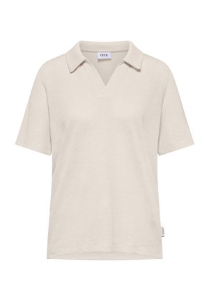 Polo en éponge beige à manches courtes avec col et ouverture en V, avec une petite étiquette latérale près de l'ourlet.