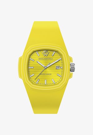 Reloj de silicona amarillo con caja octogonal, esfera amarilla texturizada, índices plateados y ventana de fecha a las tres en punto. Fabricado en Suiza.