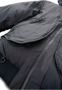 Zwarte gewatteerde jas met een gladde textuur, meerdere ritssluitingzakken en geribbelde manchetten. Lichtgewicht ontwerp met een casual uitstraling.