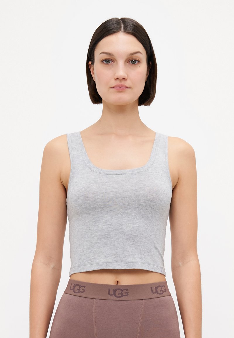 Haut crop gris en tissu doux avec un décolleté carré et des bretelles larges, associé à un legging UGG marron avec une taille logo.