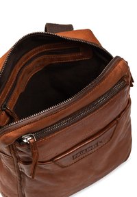 Bruine leren rugzak met een bovenste ritssluiting, voorzien van meerdere compartimenten, textuur op de buitenzijde en PIKOLINOS-merknaam aan de voorkant.