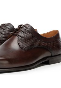 Chaussures en cuir marron avec un bout lisse et un design tissé texturé sur la tige, avec des coutures discrètes et un talon bas profilé.