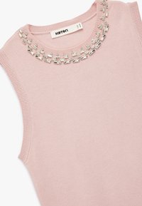 Ærmeløs lyserød sweater lavet af bomuld, med en rund halsudskæring dekoreret med sølvfarvede prydsten langs kraven.