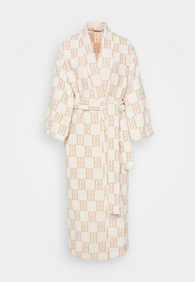 Kreemjas vannitoe mantel, millel on beež geomeetriline muster. Omab šalli kraed, laiad varrukad ja sidumisrihma, valmistatud pehmest ja tekstuurist kangast.