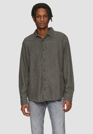 Donkergrijze spijkerblouse met een knoopsluiting aan de voorkant, puntkraag, lange mouwen en een iets relaxte pasvorm; heeft een gestructureerde stof en contrasterende stiksels.
