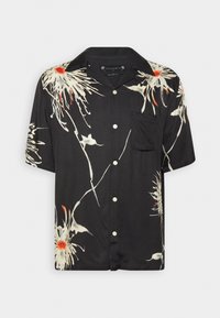 Chemise noire à manches courtes boutonnée avec des motifs floraux abstraits blancs et orange et une poche poitrine.