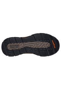 Suela de goma negra con patrones texturizados, que presenta la marca "Goodyear" y "Steady Grip". Diseñada para ofrecer tracción y durabilidad.