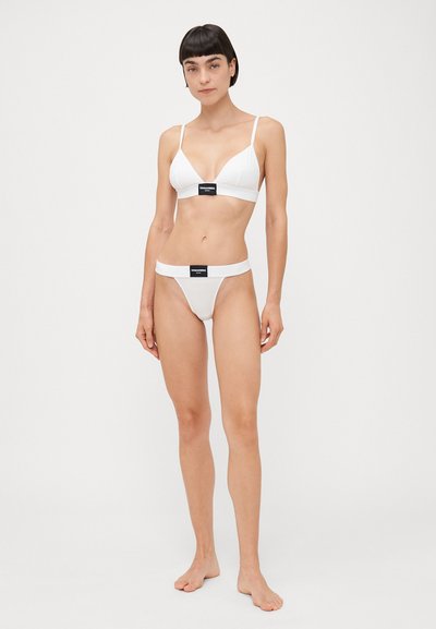 Set di lingerie in cotone bianco composto da un reggiseno a triangolo e un perizoma coordinato. Progettato con spalline sottili e un logo frontale a contrasto.