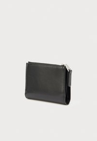 Čierna kožená peňaženka s hladkou textúrou, uzatvárateľná na zips a s kompaktným dizajnom. Má bočný záložku pre jednoduché manipulovanie a uloženie.