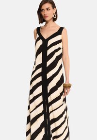 Czarna i biała, pasiasta sukienka maxi z dekoltem w kształcie litery V, gładkim materiałem i dopasowaną górą. Wyraźne ukośne paski i boczne rozcięcia.