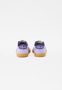 Violet krāsas zamša sporta apavi ar gumijas zoli, ar mīkstu apkaklīti un izteiksmīgu "VEJA" logotipu aizmugurē.