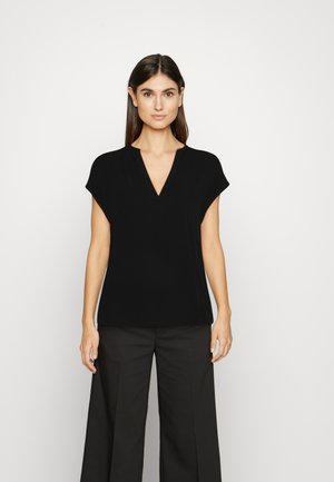 Zwarte V-hals top met korte mouwen, gladde textuur, relaxed fit en rechte zoom, gecombineerd met zwarte wijde broek.