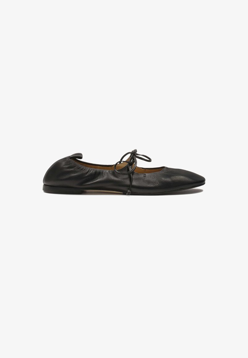 Ballarini in pelle nera con punta affusolata, bordo elastico arricciato e dettaglio a fiocco legato sulla parte anteriore. Texture liscia, design minimalista.