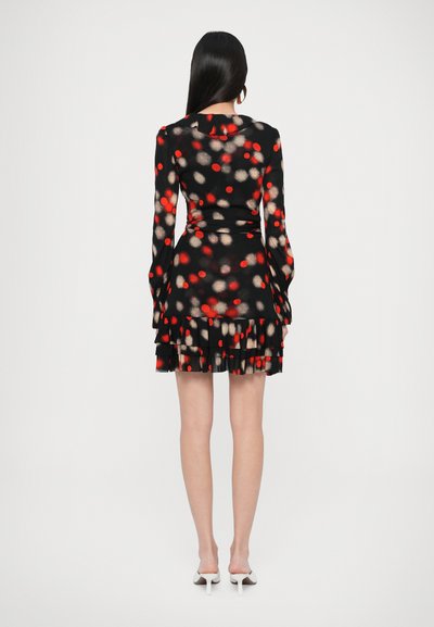 Μαύρο φόρεμα με πουά σχέδιο σε κόκκινο και μπεζ, μακριά μανίκια, βολάν στο τελείωμα και εφαρμοστή σιλουέτα.