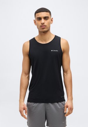 Bărbat purtând un tricou fără mâneci negru Columbia și pantaloni scurți gri, stând pe un fundal alb simplu.