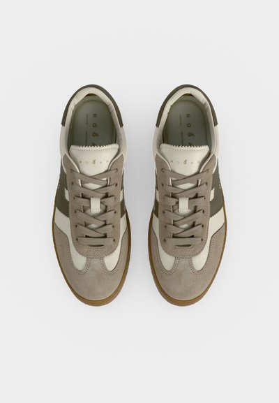 Ζευγάρι μπεζ και ελιά πράσινα sneakers με κορδόνια και λευκές λεπτομέρειες, σε θέαση από επάνω σε απλό λευκό φόντο.
