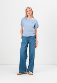Ribade sinine T-särk lühikeste varrukatega ja ümmarguse kaelusega; koos laiade siniste teksadega; oranžid tossudComplete the outfit.