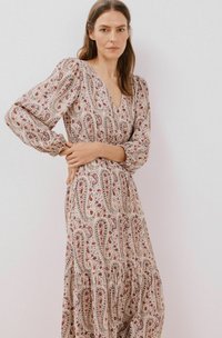Lang, patgeoorde jurk in beige met een paisley ontwerp in rood en blauw. Beschikt over een V-hals, puffmouwen en een gelaagd rokje. Zachte stoftextuur.
