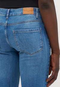 Denim jeans med en ljusblå tvätt, med en märkesläderlapp vid midjan och två bakfickor. Stryktålig textur och anpassad passform.