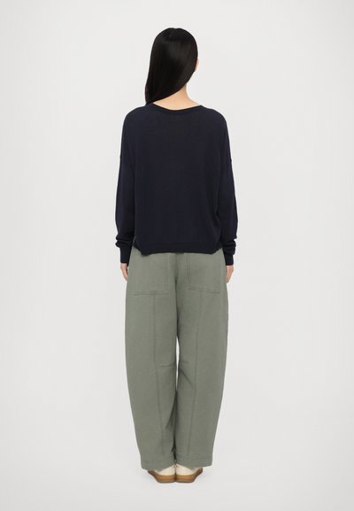 Jūras spēku pārgalvīgs džemperis ar plašu dekoltē, apvienots ar brīviem salvijas zaļas krāsas biksēm, kurām ir divi aizmugurējie kabatas un brīva piegriezuma siluets.