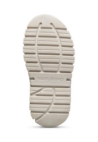 Semelle de chaussure en caoutchouc beige avec des rainures horizontales et diagonales, présentant des textures circulaires et le mot "NATURINO" en relief. Taille marquée comme "24".