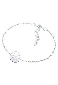 Söljd kedjearmband med en rund berlock som har präglade riktningar (N, Ö, S, V) och en liten stjärndetalj nära spännet.