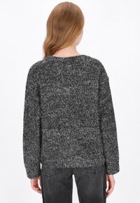 Chunky gebreide trui in een zwart-grijze mix; ronde halslijn, verlaagde schouders en geribde mouwen met een comfortabele pasvorm.