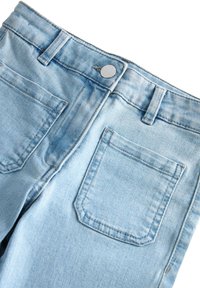 Blugi din denim de culoare albastru deschis, cu talie înaltă, design cu cinci buzunare și un finisaj neted, având un buton metalic la talie.