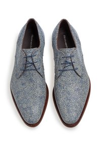 Scarpe in pelle blu con texture, dal design con punta affilata, caratterizzate da una suola in pelle marrone a contrasto e lacci blu.