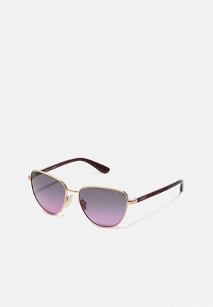 Occhiali da sole in metallo dorato con lenti a gradiente viola. Forma cat-eye, astine in plastica borgogna texturizzata. "Vogue" stampato sui lati.