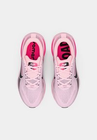 Baskets de course rose clair avec une tige en mesh, des accents noirs et une semelle amortie. Présentent un texte audacieux "COURIR" et "CHARGER" sur les semelles intérieures.