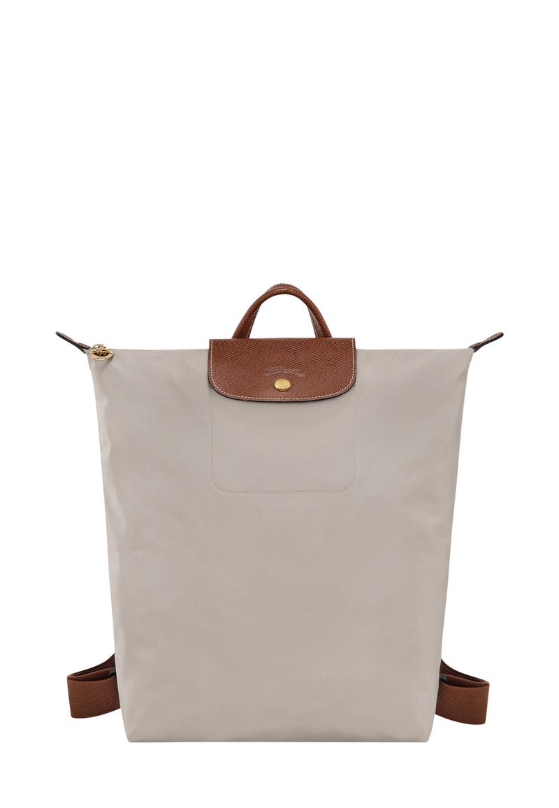 Beiger Nylonrucksack mit einer strukturierten braunen Lederklappe und -griff, goldfarbenen Beschlägen und verstellbaren braunen Riemen. Minimalistisches Design.