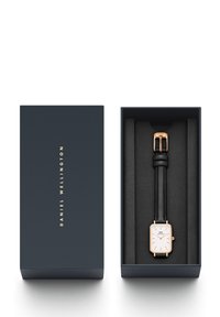 Daniel Wellington watch in a navy box. Features a rectangular white dial with rose gold accents and a black leather strap.