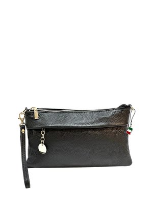 Pochette bracelet en cuir grainé noir avec fermeture éclair sur le dessus, breloque chaîne dorée, bandoulière amovible et petit drapeau rouge, blanc et vert.