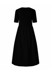 Crna haljina s uskim korzetom i kratkim rukavima, koja prelazi u punu, nabiranu suknju. Glatka tkanina u jednobojnoj boji.